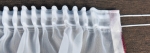 Bílá žakarová metrážová záclona s bordúrou na spodku vlnka